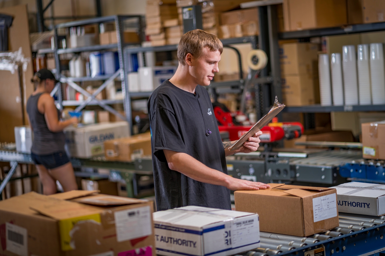 Logistics team member shipping an order and reviewing paperwork. 